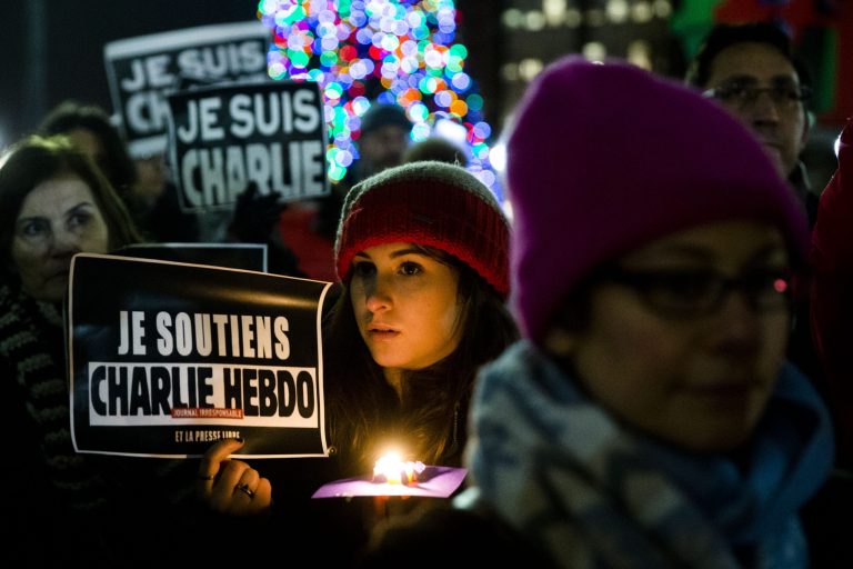 People gather to pay to pay tribute to victims of the terrorist attack against the French satirical weekly Charlie Hebdo, Friday, Jan. 9, 2015, at JFK Plaza, commonly known as Love Park, in Philadelphia. On Wednesday, masked gunmen stormed the Paris offices of the weekly newspaper that caricatured the Prophet Muhammad, killing at least 12 people, including the editor. (AP Photo/Matt Rourke)