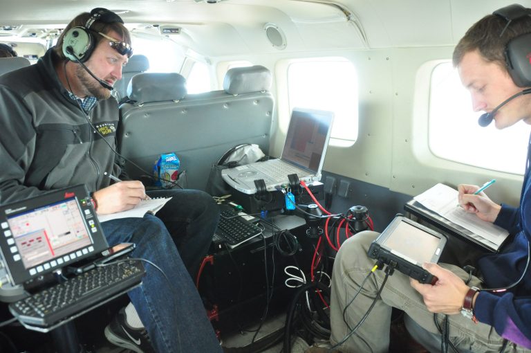 In this photo taken in October 2012, released by WSI, a Quantum Spatial Company,  sensor operators Lennie Rummel left, and Drew Wendeborn, right, are shown inside a helicopter taking measurements with LIDAR, a high-tech laser system mounted on the aircraft, to build a detailed elevation map of the terrain above Omak, Wash. The maps can be used by planners and homeowners to begin to assess landslide risk. (AP Photo/ WSI, a Quantum Spatial Company)