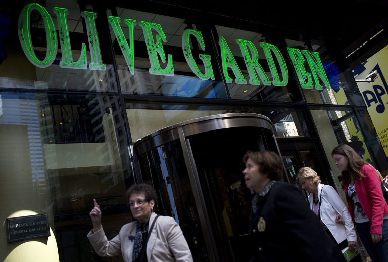 Pedestrians pass in front of an Olive Garden restaurant in New York, U.S., on Wednesday, Sept. 19, 2012. Darden Restaurants Inc., operators of casual dining restaurants in North America, is scheduled to release earnings data on Sept. 21. Photographer: Victor J. Blue/Bloomberg