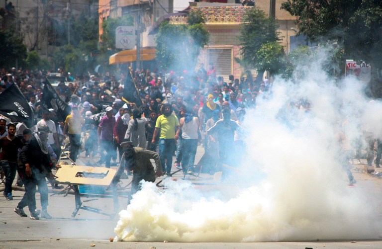 Radical Islamist movement Ansar al-Shariah supporters clash with Tunisian police officers after Tunisia's Interior Ministry on Friday banned their annual conference supposed to be held in Kairouan, in Ettadhamen, near Tunis, Sunday May 19, 2013. Massive numbers of Tunisian police and army surrounded Tunisia's religious center of Kairouan to prevent a conference by a radical Islamist movement that has been implicated in attacks around the country. (AP Photo/Nawfel)