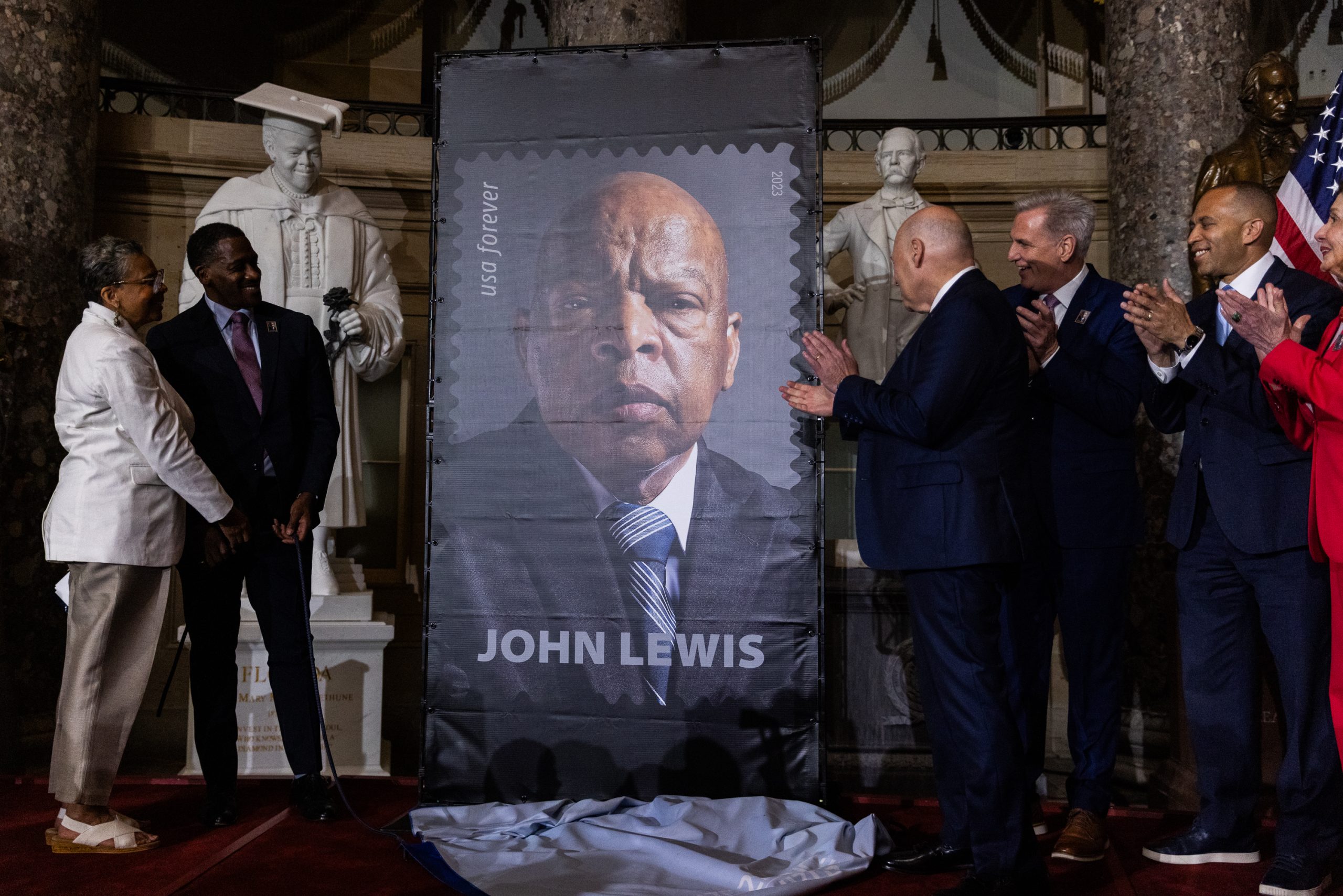 U.S. Postmaster General Louis DeJoy, along with members of Congress and staff, unveils a stamp at a ceremony in honor of the late congressman and civil rights activist John R. Lewis, in Statuary Hall at the U.S. Capitol on June 21, 2023, in Washington, DC. Lewis spent more than 30 years in Congress and passed away in July 2020 from pancreatic cancer.