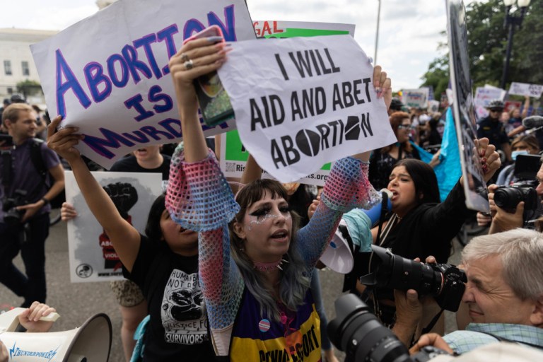 Pro-abortion rights protesters use signs and other items in opposition to the overturning of Roe v. Wade on Friday in Washington.