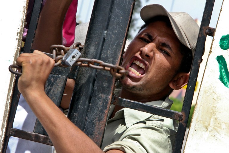 An Egyptian border policeman shouts at the closed Rafah, Sinai border crossing between Egypt and the Gaza strip to protest the abduction of his colleagues last Thursday in northern Sinai, in Rafah, Egypt, Sunday, May 19, 2013. Rafah, the main crossing point into the Gaza Strip, was closed by policemen Friday, barring people from going in or out of the Palestinian territory. Scores of protesting Egyptian police have also shut down the Awja commercial border crossing with Israel Sunday. (AP Photo/Roger Anis, El Shorouk Newspaper) EGYPT OUT