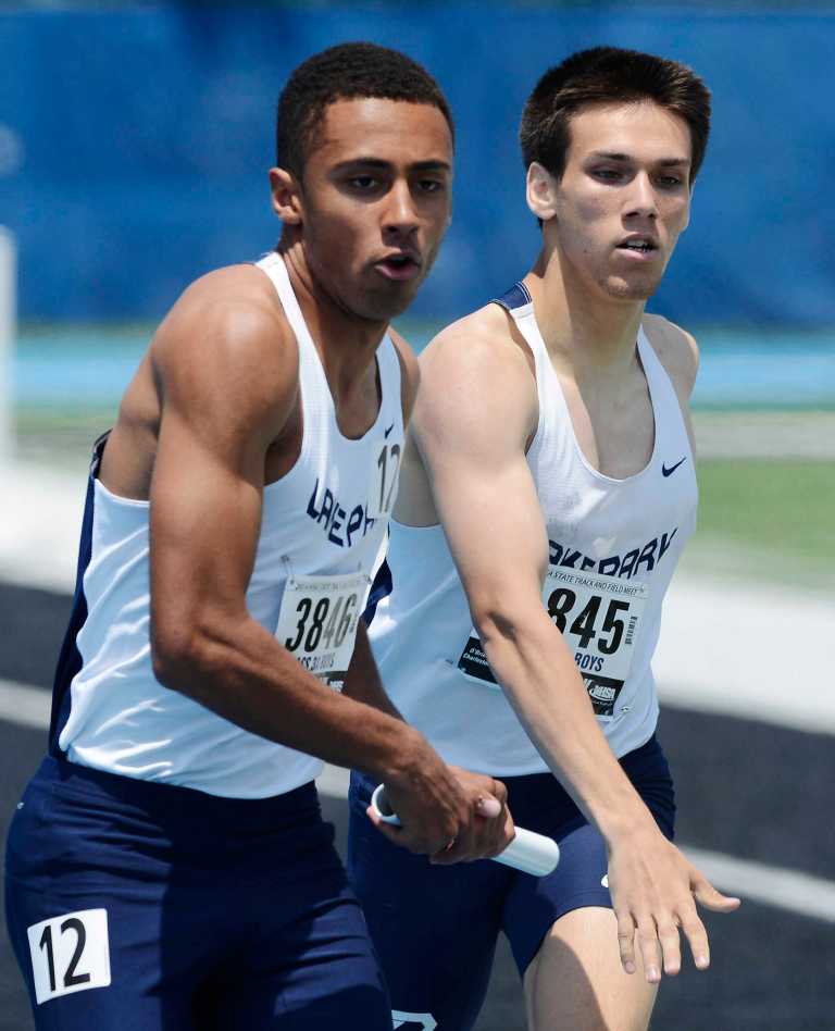 Lake Park's Lucas Bracher, left, takes the baton from teammate Lucas Bracher in the 3,200--meter relay during the preliminaries of the IHSA boys track and field meet Friday, May 30, 2014, in Charleston, Ill. (AP Photo/Daily Herald, Joe Lewnard)