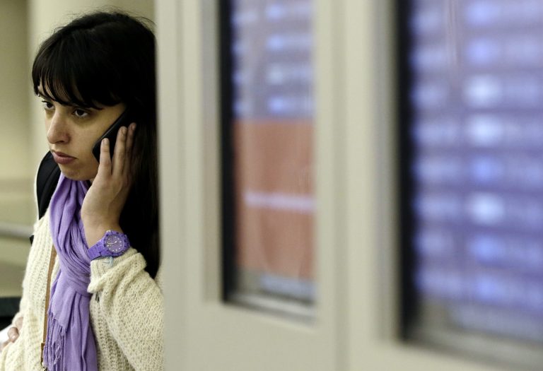   FILE - In this Thursday, Dec. 20, 2012, file photo, a passengers reacts as she talks on her phone at Midway airport in Chicago. A massive winter storm is disrupting travel plans for tens of thousands of fliers trying to get home after Christmas on Wednesday, Dec. 26, 2012. Snow, thunderstorms, sleet, tornados and high winds have grounded planes in the nation's midsection and are expected to slow operations on the East Coast. (AP Photo/Nam Y. Huh, File)  