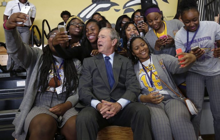 Former President George W. Bush poses for photos with students at Warren Easton Charter High School in New Orleans, Friday, Aug. 28, 2015. (AP Photo/Gerald Herbert)
