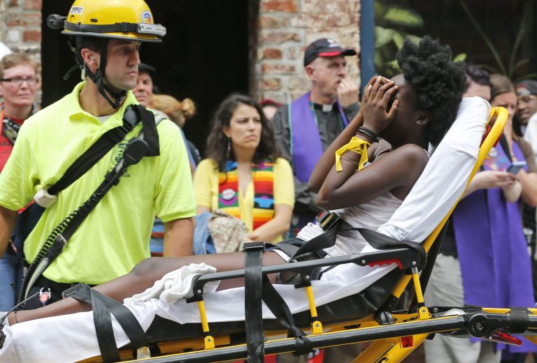 Rescue personnel help an injured woman after a car ran into a large group of protesters after an white nationalist rally in Charlottesville, Va., Saturday, Aug. 12, 2017. The nationalists were holding the rally to protest plans by the city of Charlottesville to remove a statue of Confederate Gen. Robert E. Lee. There were several hundred protesters marching in a long line when the car drove into a group of them.(AP Photo/Steve Helber)