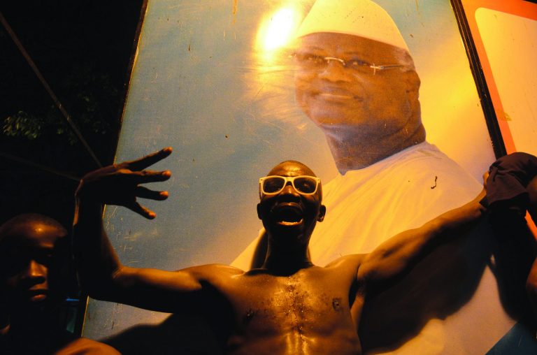 A supporter of the ruling All People's Congress celebrates next to a poster of incumbent President Ernest Bai Koroma after Koroma was pronounced the winner of last week's presidential election, in Freetown, Sierra Leone, Friday, Nov. 23, 2012. Sierra Leone's incumbent president handily won re-election and was sworn in late Friday by the country's chief justice, as the capital of the war-scarred country erupted in drumming and celebration.(AP Photo/Tommy Trenchard)