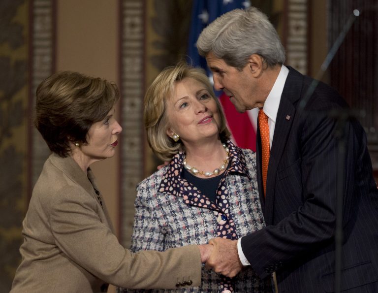 from left, former first lady Laura Bush, former Secretary of State Hillary Rodham Clinton, and Secretary of State John Kerry greet each other on stage at Gaston Hall Georgetown University in Washington, Friday, Nov. 15, 2013, during the 
