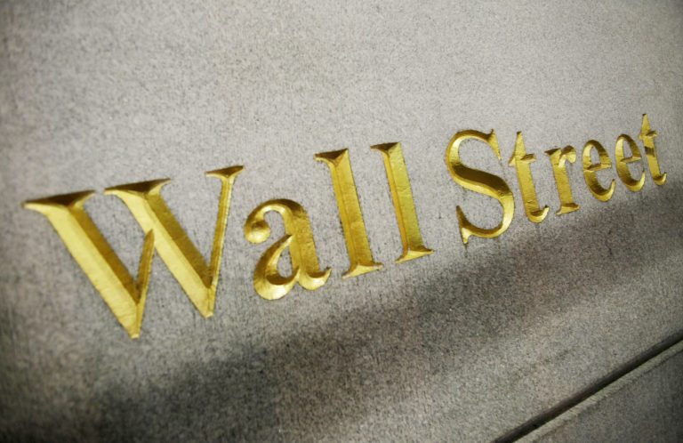This Oct. 8. 2014 photo shows a Wall Street address carved into the side of a building in New York. U.S. stocks were solidly lower in early trading Thursday, Oct. 9, 2014, pruning back some of the gains from a massive rally the day before. Gap shares plunged after the company announced its CEO was retiring. (AP Photo/Mark Lennihan)