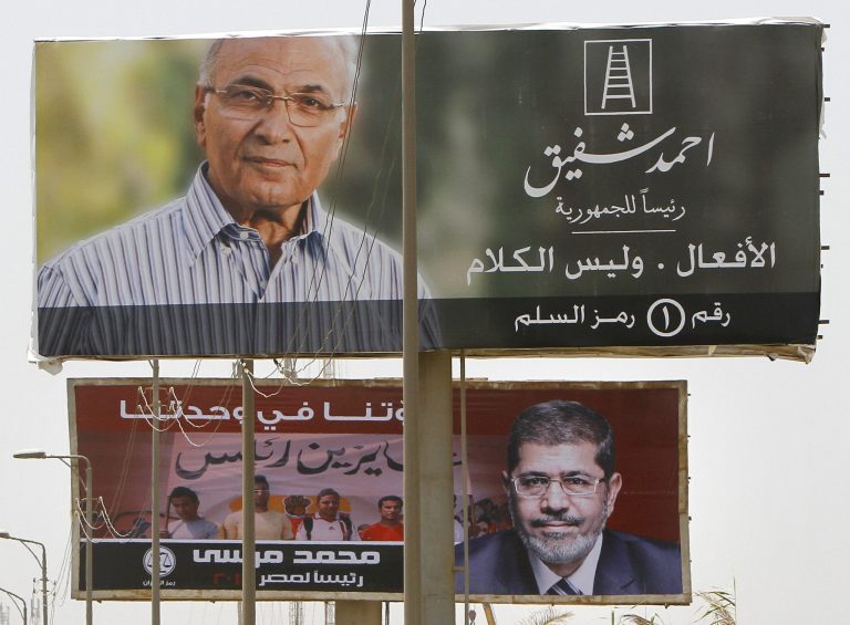   Giant billboards showing Egyptian presidential candidates Ahmed Shafiq, top, and Mohammed Morsi, bottom, are seen along a highway in Cairo, Egypt, Monday, June 11, 2012. Shafiq, the last prime minister of deposed President Hosni Mubarak, will face the Muslim Brotherhood's candidate, Mohammed Morsi, in a runoff on June 16-17. Arabic sign, top, reads, 
