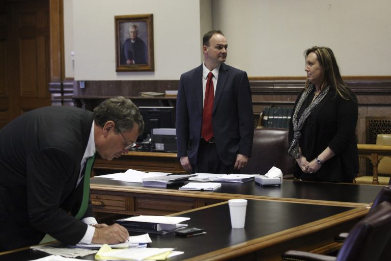 Mike Short, left, Lee County prosecuting attorney, gets ready for his opening argument in a trial against Kelli Jo Griffin, right, and her attorney Curtis Dial, center, Wednesday, March 19, at the South Lee County Courthouse in Keokuk, Iowa. (AP Photo/The Hawk Eye, John Gaines)