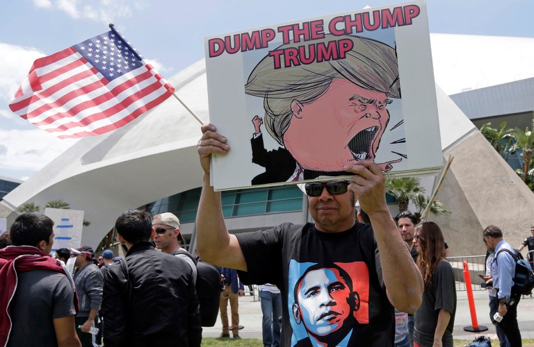 A protester holds a sign during a protest outside rally for Republican presidential candidate Donald Trump at the Anaheim, Calif., Convention Center. (AP Photo/Nick Ut)