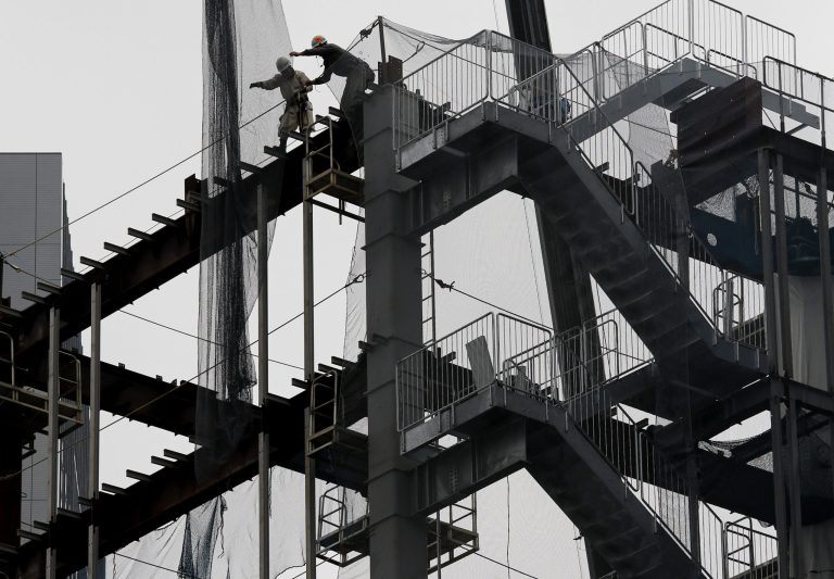 FILE - In this March 1, 2014 file photo, workers reach for the net at a construction site in Tokyo. Japan raised its estimate of January-March quarter economic growth Monday, June 9, 2014 as investment by companies was stronger than first thought. (AP Photo/Shuji Kajiyama, File)