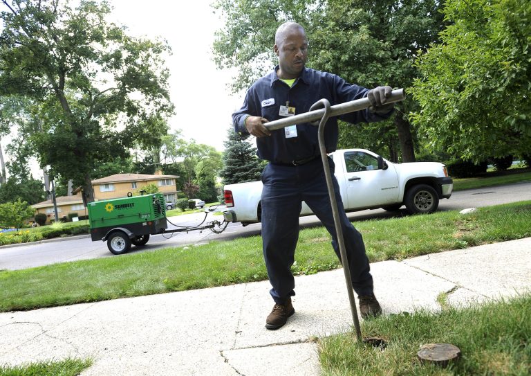 Chester Clemons, a water shut-off technician for the city of Detroit, shuts off the water at a home in the Palmer Woods neighborhood of Detroit, Mich., on Wednesday,July 8, 2014. The Detroit Water and Sewerage Department is putting businesses on notice that it will shut off water service if they don't pay their bills following recent efforts to crack down on residential customers who are in arrears. (AP Photo/The Detroit News, Elizabeth Conley)