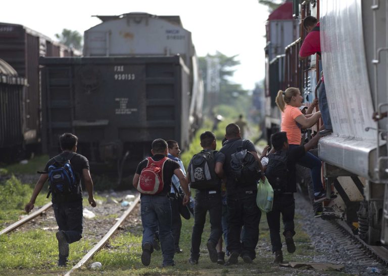 In this Saturday, July 12, 2014 file photo, immigrants run to jump on a train during their journey toward the U.S.-Mexico border, in Ixtepec, Mexico. (AP Photo/Eduardo Verdugo)