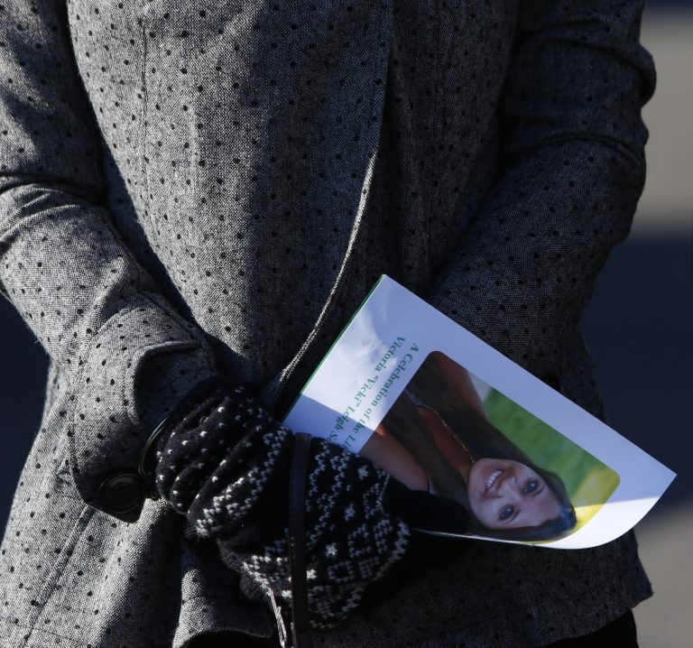  A mourner carries a program as she leaves the funeral service of Victoria Soto at Lordship Community Church, Wednesday, Dec. 19, 2012, in Stratford, Conn. Soto was killed when Adam Lanza walked into Sandy Hook Elementary School in Newtown, Conn., Dec. 14, and opened fire, killing 26 people, including 20 children, before killing himself. (AP Photo/Jason DeCrow)  