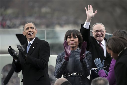 President Barack Obama and first lady Michelle Obama applaud, as Sen. Charles Schumer, D-N.Y., chairman of the Joint Congressional Committee on Inaugural Ceremonies waves on the West Front of the Capitol in Washington, Monday, Jan. 21, 2013, prior to Obama's ceremonial swearing-in ceremony during the 57th Presidential Inauguration.  (AP Photo/Win McNamee, Pool)