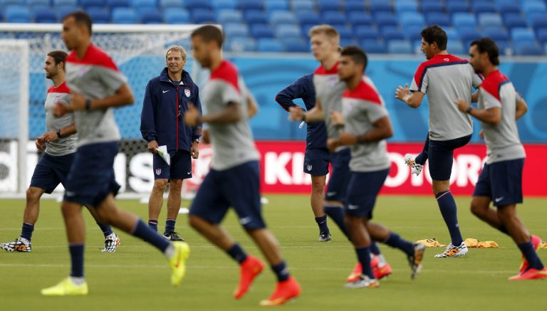 United States' head coach Jurgen Klinsmann, back left, looks on as his team warms up during an official training session the day before the group G World Cup soccer match between Ghana and the United States at the Arena das Dunas in Natal, Brazil, Sunday. (AP Photo/Julio Cortez)
