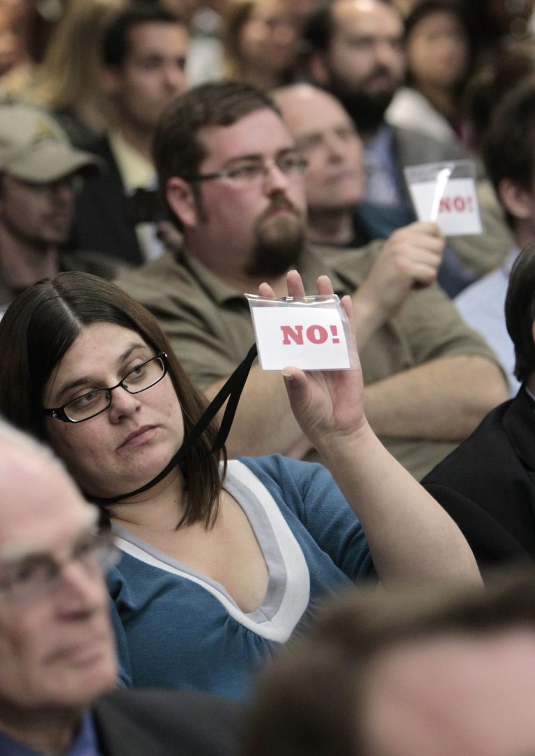 Members of the audience hold up 