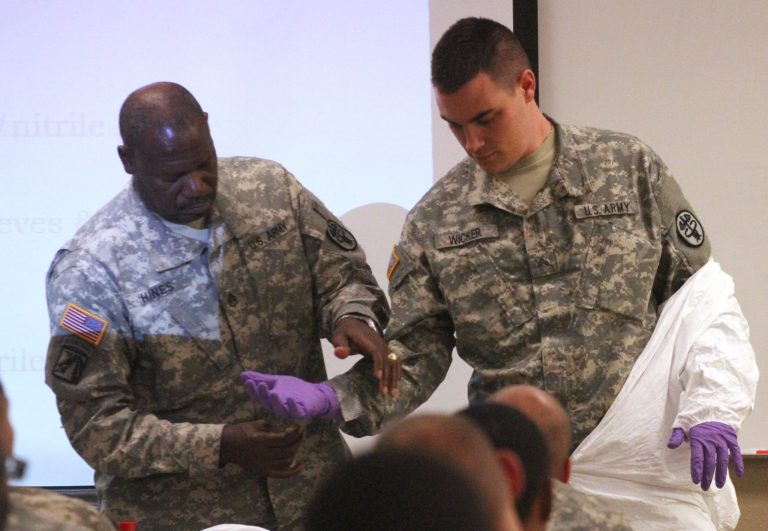 Army Stf. Sgt. Samuel Hines, left, helps Cpl. Zachary Wicker tape gloves to his uniform in Fort Bliss, Texas, Tuesday, Oct. 14, 2014.Â An United States-based emergency Ebola response team is being prepped, the Department of Defense said Sunday.Â  (AP Photo/Juan Carlos Llorca)
