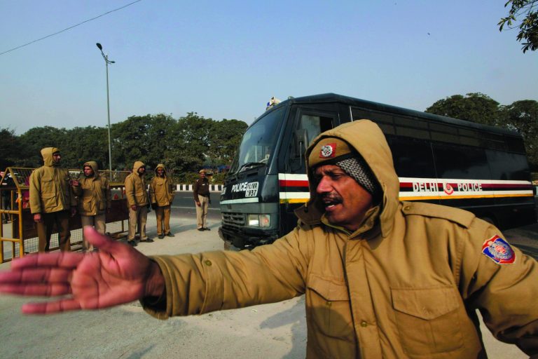 A police officer clears the way for a police van believed to carrying five men accused in a gang rape as they arrive at the district court, in New Delhi, India, Monday, Jan. 7, 2013. The men, who were set to appear in court Monday, are accused of the Dec. 16 gang rape on a woman, who later died of her injuries, that has caused outrage across India, sparking protests and demands for tough new rape laws. (AP Photo/Manish Swarup)