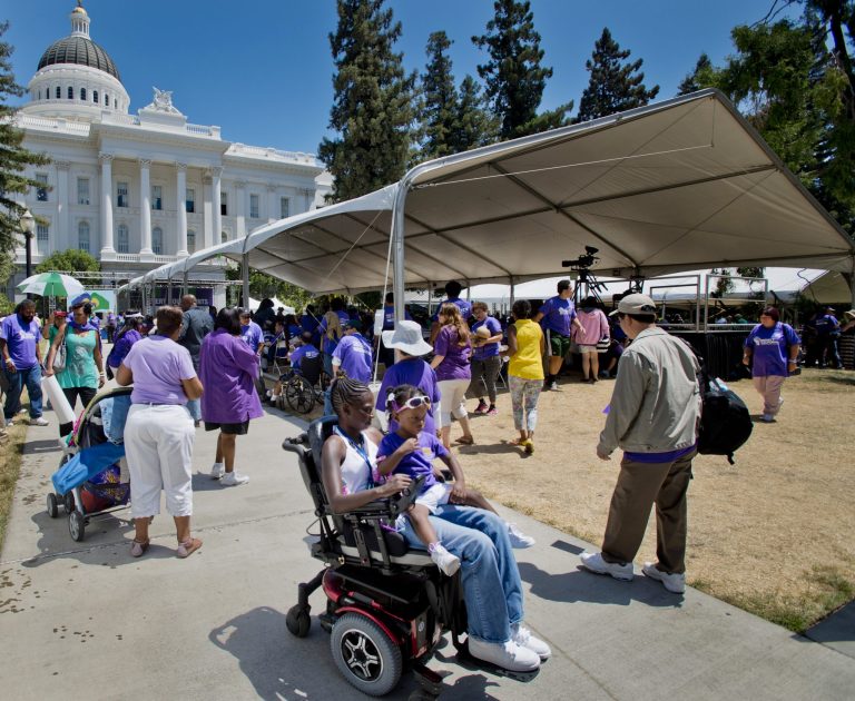 In this photo taken Thursday, June 5, 2014, home care providers and the seniors and people with disabilities for whom they provide care, call for increased state funding during a rally at the Capitol in Sacramento, Calif.  Gov. Jerry Brown and lawmakers head into the final week of budget negotiations, having reached agreements in many areas of state spending, but Democrats who control both houses of the legislature want to use extra cash to restore services for the poor which were cut during California's past multibillion budget shortfalls. (AP Photo/The Sacramento Bee, Manny Crisostomo)