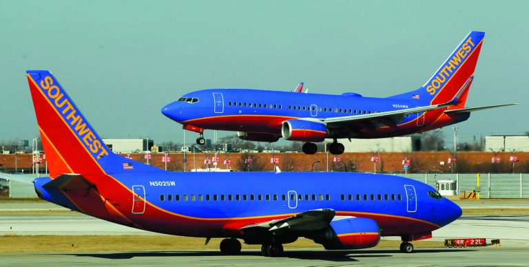 FILE - In this Feb. 9, 2012, file photo, a Southwest Airlines Boeing 737 waits to take off at Chicago's Midway Airport as another lands. The government can require airlines to show consumers a total ticket price that includes taxes and fees in print and online ads, the U.S. Court of Appeals said Tuesday, July 24, 2012, rejecting an industry challenge to a series of consumer protection regulations. The Department of Transportation, which issued the regulations last year, has the authority to regulate 