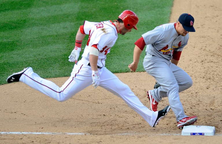 St. Louis Cardinals relief pitcher Trevor Rosenthal, right, beats Washington Nationals' Bryce Harper to first base for an out in the seventh inning of Game 3 of the National League division baseball series on Wednesday, Oct. 10, 2012, in Washington. (AP Photo/Nick Wass)