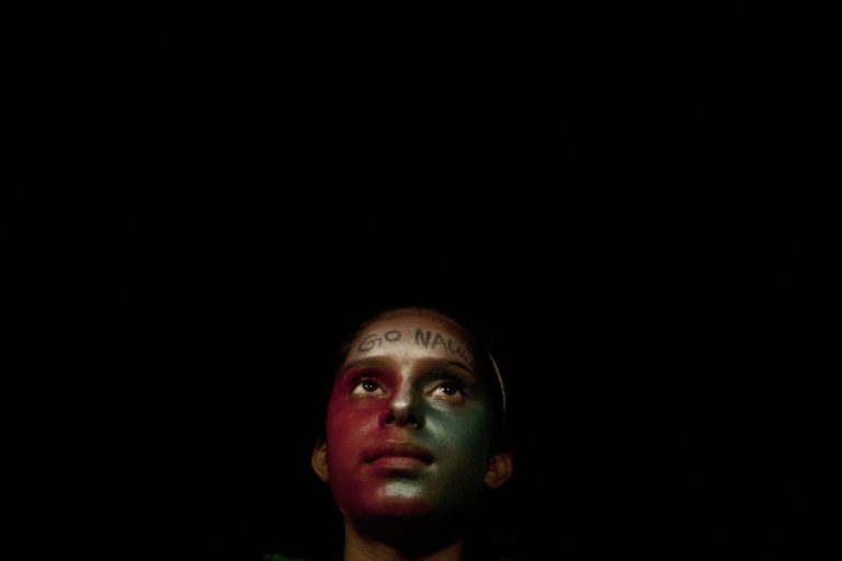 A supporter of Pakistan's cricket celebrity-turned-politician Imran Khan takes part in an anti-government rally with writing on her forehead  