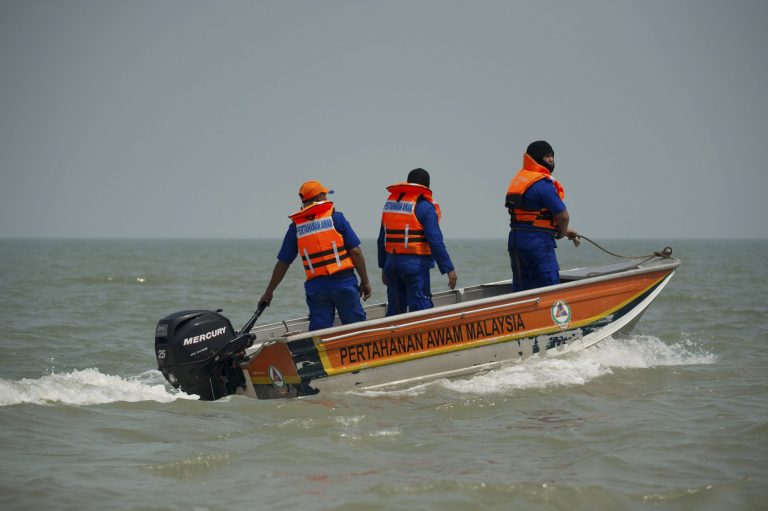 Members of Malaysian Civil Defense Department on a speed boat search for missing Indonesians of a sunken boat off west coast in Banting, outside Kuala Lumpur, Malaysia, Thursday, June 19, 2014. An overcrowded wooden boat on Wednesday carrying Indonesian illegal immigrants home sank in choppy seas, with 25 people still missing. Ten people died in that accident, but at least 62 people survived. (AP Photo)