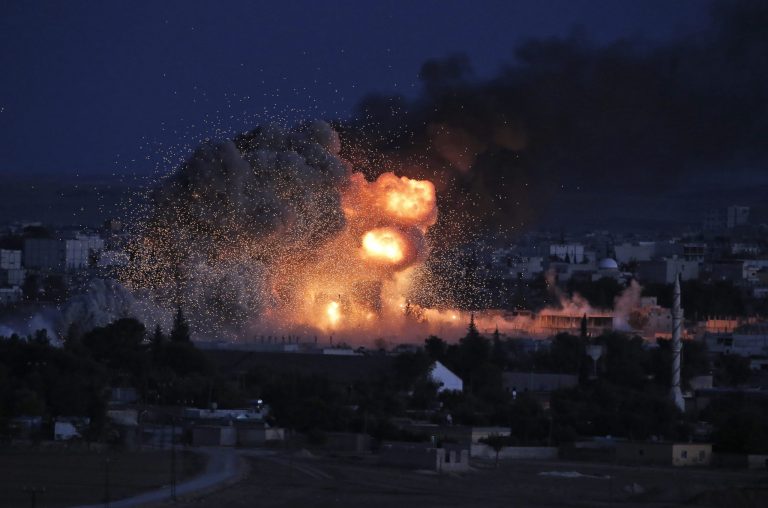Smoke and flames from an airstrike by the US-led coalition rise in Kobani, Syria, as seen from a hilltop on the outskirts of Suruc, at the Turkey-Syria border, Monday, Oct. 20, 2014 Kobani, also known as Ayn Arab, and its surrounding areas, has been under assault by extremists of the Islamic State group since mid-September and is being defended by Kurdish fighters. (AP Photo/Lefteris Pitarakis)