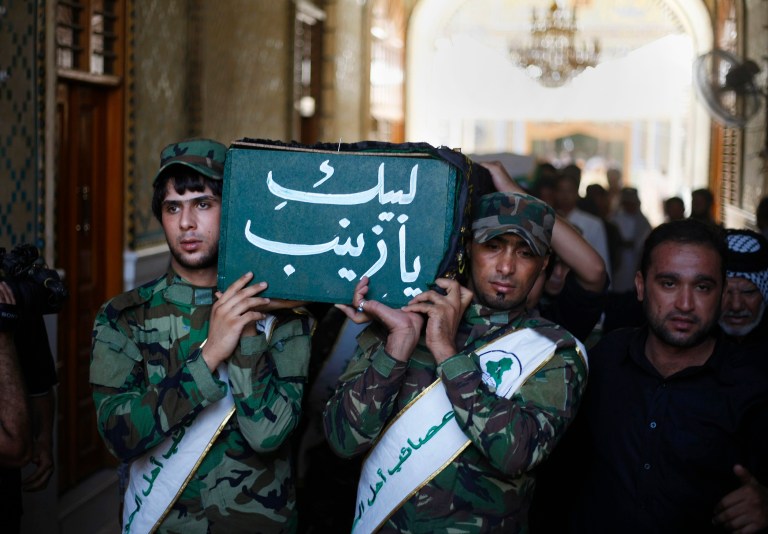   Members of Iraq's Hezbollah Brigades carry the coffin of a Shiite fighter, Methaq Najm Abdullah, during a funeral procession in the Shiite holy city of Najaf, 100 miles (160 kilometers) south of Baghdad, Iraq, Thursday, Aug. 22, 2013. Three Iraqi Shiite fighters were killed in Syria a few days ago, Iraq Hezbollah Brigades officials said on Thursday. (AP Photo)  