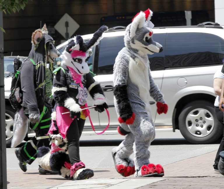   In this photo made on Thursday, June 14, 2012, people in animal costumes walk down Penn Ave. near the David Lawrence Convention Center in Pittsburgh. Anthrocon, the world's largest convention for people who dress and assume the rolls of fictional animal characters, is back in its adopted home with an expected 5,000 participants between June 14 to 17, 2012. (AP Photo/Keith Srakocic)  