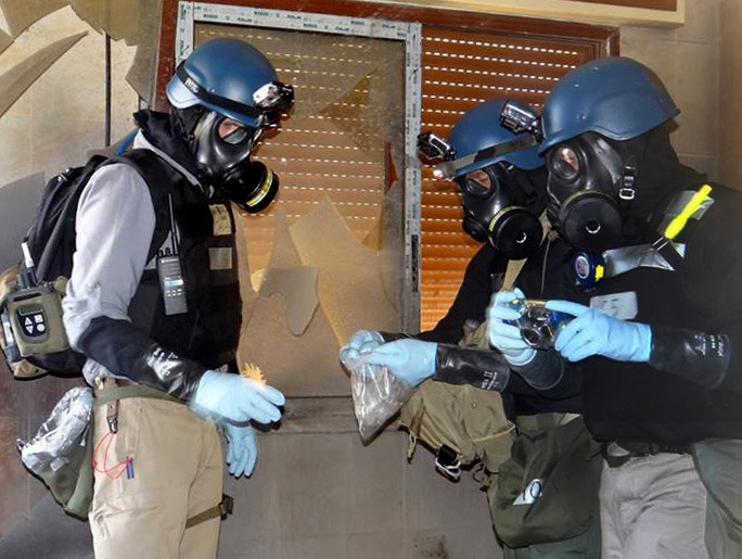 FILE - In this Thursday, Aug. 29, 2013 file citizen journalism image provided by the Local Committee of Arbeen which has been authenticated based on its contents and other AP reporting, members of the UN investigation team take samples from the ground in the Damascus countryside of Zamalka, Syria. The chemical weapons watchdog that is overseeing the dismantling of Syria's chemical weapons program said Tuesday, May 27, 2014 that a convoy of its inspectors has come under attack, but all are safe. The Organization for the Prohibition of Chemical Weapons said  the inspectors had been traveling to the site of an alleged chlorine gas attack site when they were attacked. (AP Photo/Local Committee of Arbeen, File)