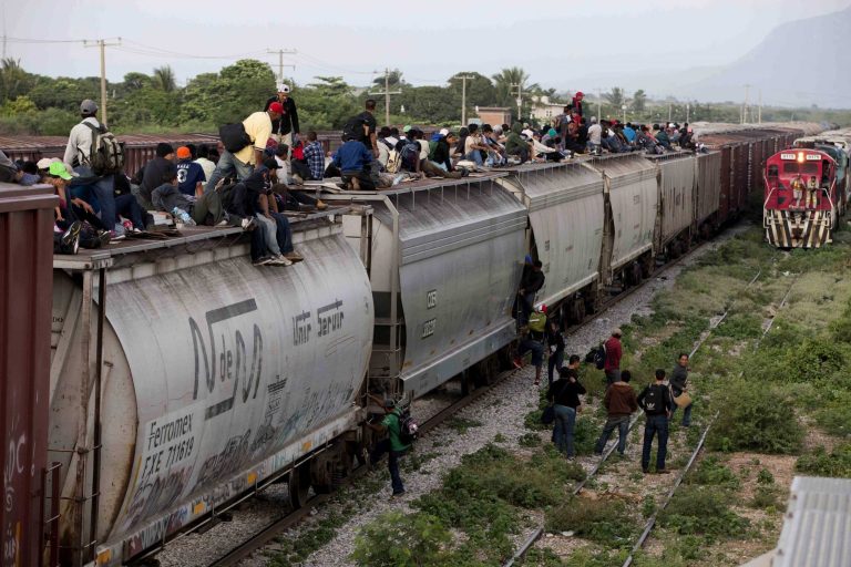 Central American migrants ride a freight train during their journey toward the U.S.-Mexico border in Ixtepec, Mexico. (AP/Eduardo Verdugo)