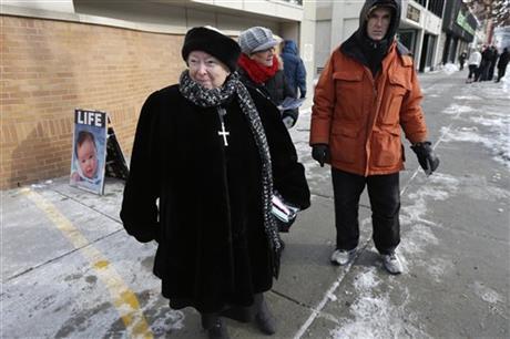 This photo taken Dec. 17, 2013 shows anti-abortion protester Eleanor McCullen, of Boston, left, standing at the painted edge of a buffer zone outside a Planned Parenthood location in Boston. AP Photo