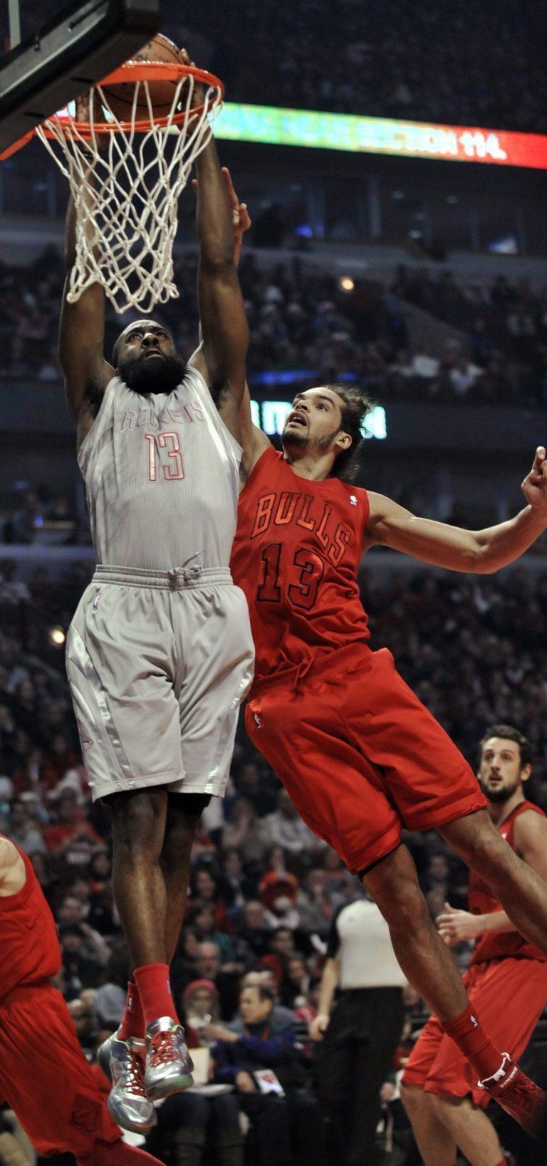   Houston Rockets' James Harden, left, dunks over Chicago Bulls' Joakim Noah during the first quarter of an NBA basketball game in Chicago, Tuesday, Dec. 25, 2012. (AP Photo/Paul Beaty)  