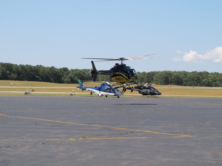 In this Aug. 20, 2014 photo, a helicopter tales off in front of two other choppers at East Hampton Town Airport. Residents across eastern Long Island are complaining about the noise generated from jets, helicopters and other aircraft that land at the small municipal airport, which is situated in the heart of the summer playground for the rich and famous. (AP Photo/Frank Eltman)