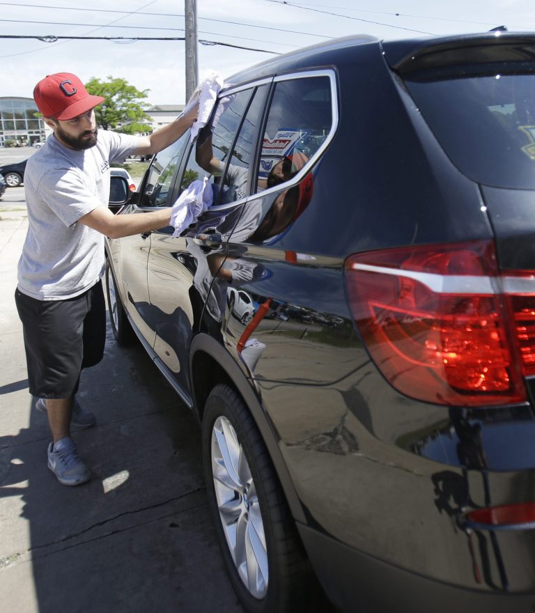 In this Friday, June 6, 2014 photo, Anthony Scharf dries a car at a car wash in Woodmere Village, Ohio. The Labor Department releases second-quarter productivity data on Friday, Aug. 8, 2014. (AP Photo/Tony Dejak)