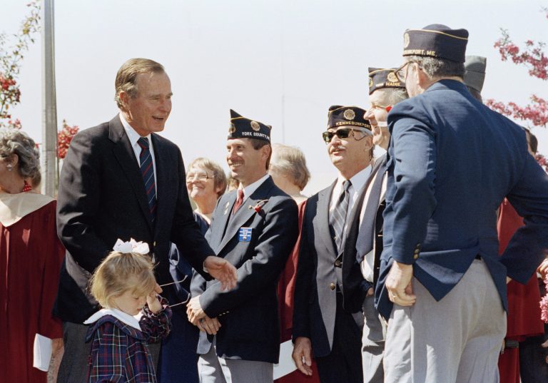 Marshall Bush, 3, with her grandfather, President George H W Bush, as he greets veterans of war at a memorial ceremony on May 27, 1990 in Kennebunkport, Maine. A local townsman who was killed in Vietnam was honored during the brief ceremony. (AP Photo/Marcy Nighswander)