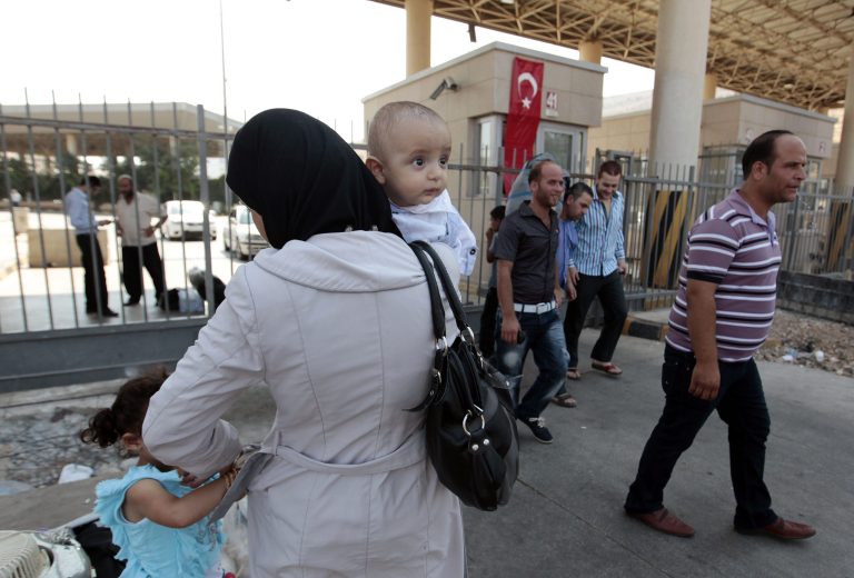   Syrian refugees pass through the Turkish Cilvegozu gate border with Syria, Friday, Aug. 30, 2013. United Nations experts are investigating the alleged use of chemical weapons in Syria as the United States and allies prepare for the possibility of a punitive strike against President Bashar Assad's regime, blamed by the Syrian opposition for the attack. The international aid group Doctors Without Borders says at least 355 people were killed in the Aug. 21 attack. (AP Photo/Gregorio Borgia)  