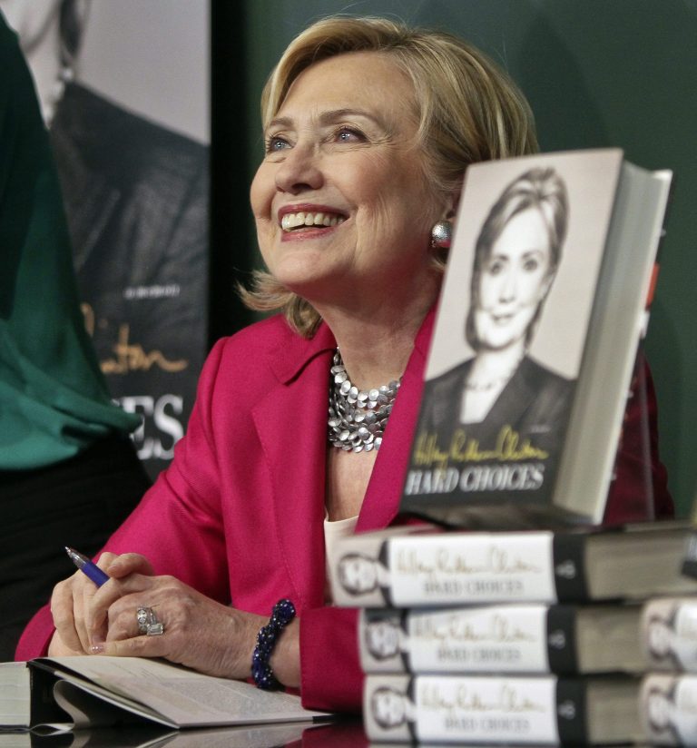 HiIlary Rodham Clinton listens before signing a copy of her book, 