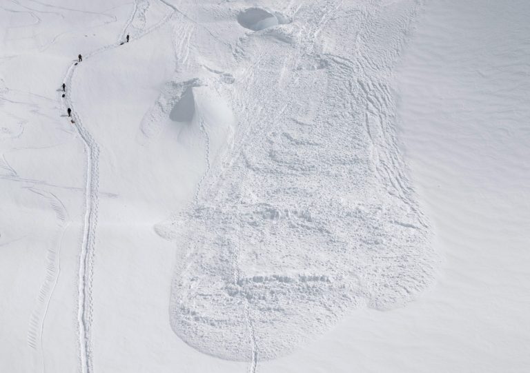   In this Friday, June 15, 2012 photo provided by the National Park Service, climbers hike through the area where an avalanche swept a Japanese climbing team off a hill during their descent from Alaska's Mount McKinley. U.S. National Park Service officials say five people were traveling as a one rope team early Thursday morning as part of a Miyagi Workers Alpine Federation expedition on the Alaska mountain. The NPS said Hitoshi Ogi, 69, survived after falling 60 feet (18 meters) into a crevasse. He was able to climb out. The other four tumbled into the avalanche debris and haven't been seen since. (AP Photo/National Park Service, Kevin Wright)  
