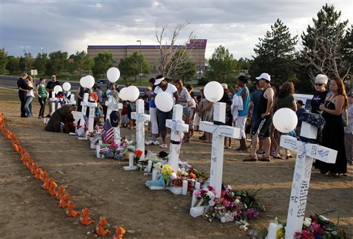 People visit a memorial for the victims in the shooting across the street from the Century 16 movie theater in Aurora, Colo., Sunday, July 22, 2012. James Eagen Holmes has been charged in the shooting at the Aurora theater early Friday that killed twelve people and injured more than 50.He is scheduled to appear in court Monday morning. (AP Photo/Ed Andrieski)