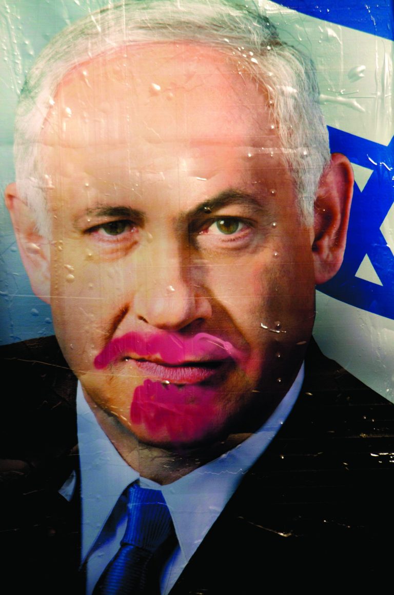 A vandalized election campaign billboard of Israeli Prime Minister and Likud Party leader Benjamin Netanyahu hangs on a main road in Tel Aviv, Israel, Monday, Jan. 21, 2013. The general elections will be held on Tuesday, Jan. 22, 2013. (AP Photo/Ariel Schalit)