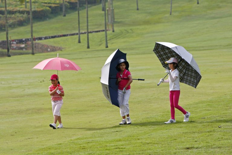  In this photo taken on Wednesday, Dec. 5, 2012, Kelly Low, left, of Malaysia, Ariane Cazaubon, center, of the United States, and Kristin Lee of Indonesia walk on the fairway during the Kids Golf World Championship at Glenmarie Golf and Country Club in Shah Alam, outside Kuala Lumpur, Malaysia. Golf is no longer just an adult's game in Asia. It is fast becoming child's play as many parents nurture their kids from increasingly young ages, giving them a head start on a path to a professional career. (AP Photo/Lai Seng Sin)  