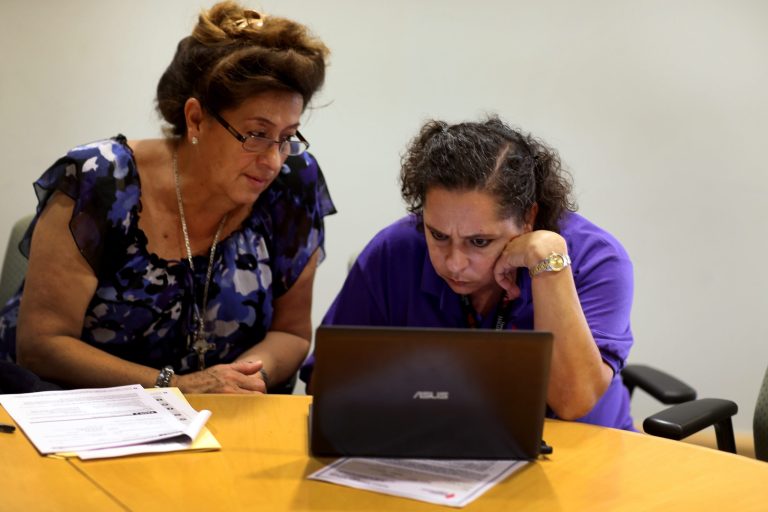 Affordable Care Act navigator Nini Hadwen works with Marta Aguirre as she shops for health insurance on Oct. 8 in Miami, Florida. (Joe Raedle/Getty Images)