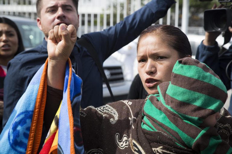 Immigrant rights activist Elvira Arellano waits to enter into the United States where she planned to ask for asylum in Tijuana, Mexico, Tuesday, March 18, 2014. Arellano and another 20 Mexican and Central American migrants crossed into the United States from the border city of Tijuana as part of a protest to demand an overhaul of U.S. immigration laws and an end to deportations. (AP Photo/Alex Cossio)