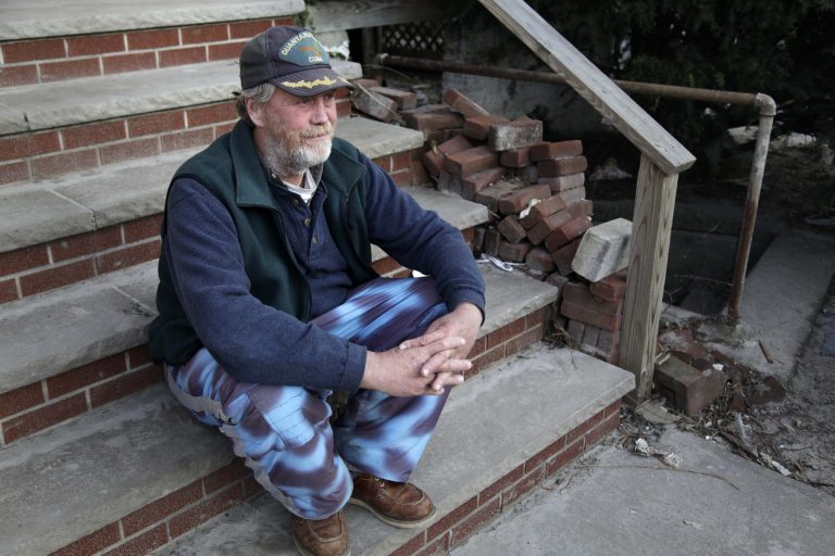   John Frawley sits on the porch of his house, which was damaged during Superstorm Sandy, on the Rockaway Peninsula in New York, Thursday, Nov. 29, 2012. Uncounted numbers of families have returned to coastal homes that are contaminated with mold, which can aggravate allergies and leave people perpetually wheezing. Others have been sleeping in houses filled with construction dust, as workers have ripped out walls and flooring. That dust can sometimes trigger asthma. (AP Photo/Seth Wenig)  